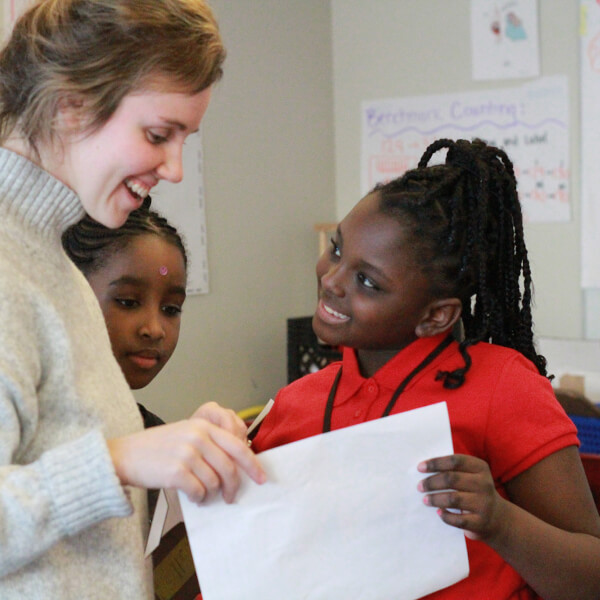 A teacher looks over the paper of a student in her classroom.